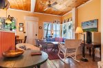 Enter in the cottage and you are greeted by the large living area with high ceilings including a kitchen, sitting area with TV, Dining area, and full bath